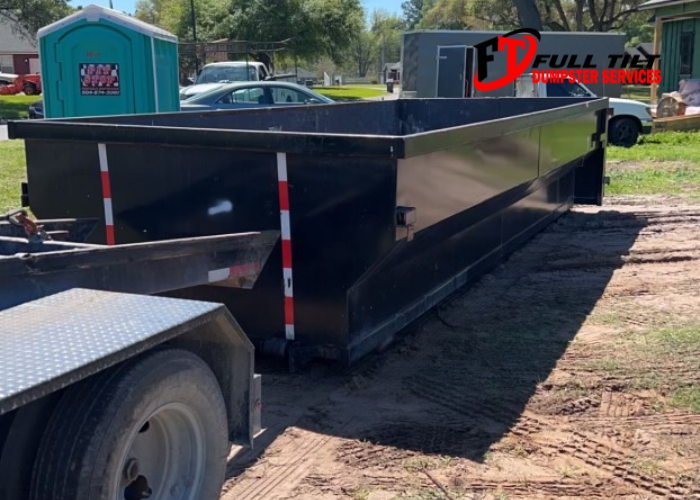 a dumpster rental next to a port-a-potty on a job site in Macclenny, FL